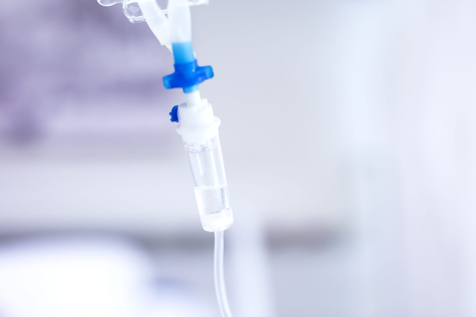 Close-up of an intravenous (IV) drip chamber in a medical setting.