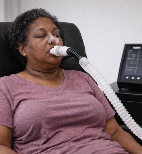 Woman using a CPAP machine for sleep apnea treatment.